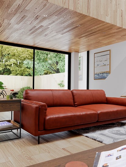 Industrial styled brown leather sofa with metal legs sitting in a living room with wooden floors