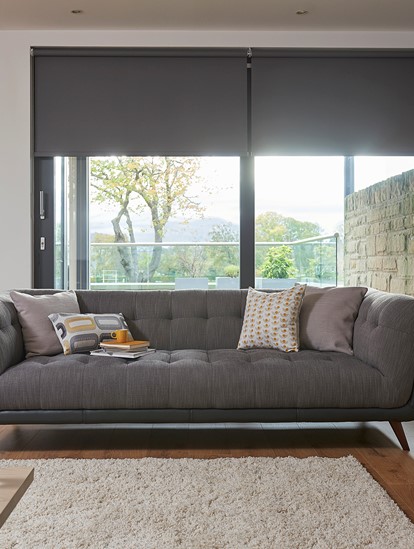 A mid century modern sofa in grey and black shown in a modern living room
